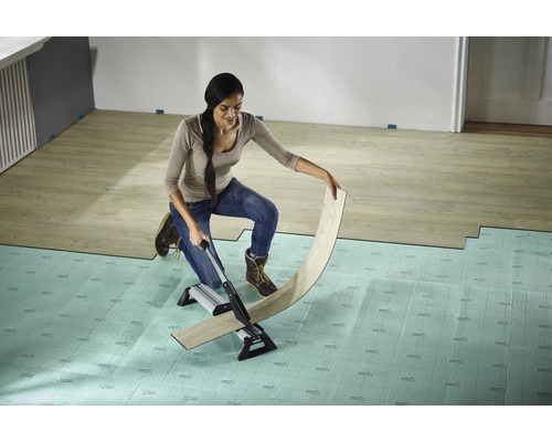 Femme coupant du stratifié avec un coupe-stratifié sur une sous-couche