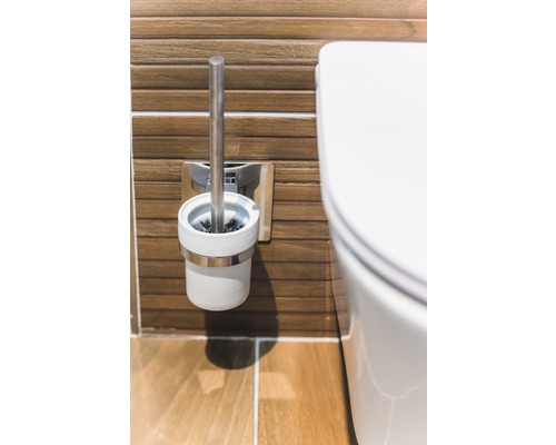 Brosse de toilette et cuvette de toilettes dans une salle de bains