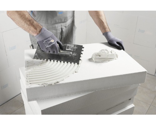 Application de colle sur une plaque de béton cellulaire à l''aide d''une truelle