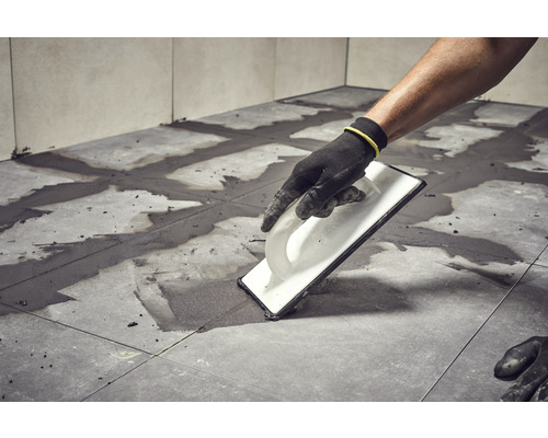 Jointoiement de carreaux avec une taloche à joints