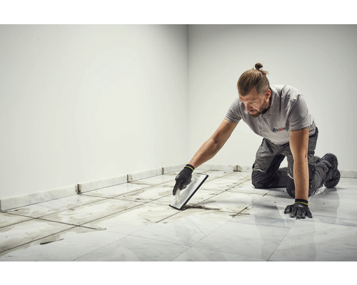 Un homme joint des carreaux à l''intérieur.