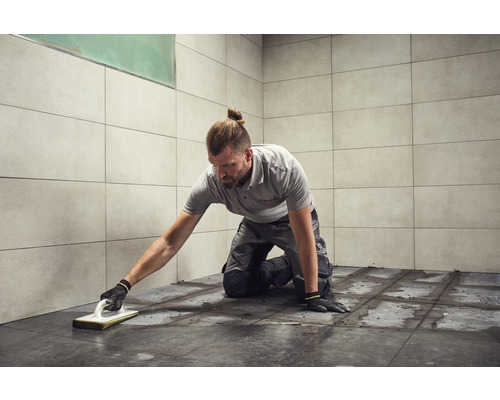 Carreleur joint les carreaux dans la salle de bain