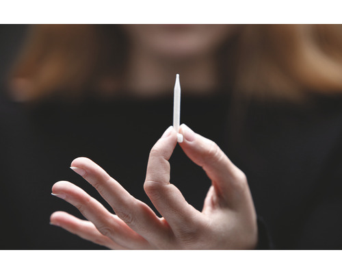 Une main tient un injecteur.