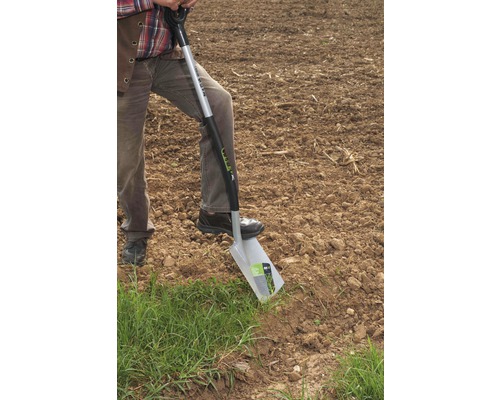 Eine Person benutzt einen Spaten zum Graben im Garten.