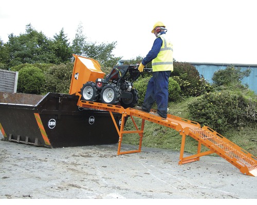 Une personne utilise un mini-dump qui se vide dans un conteneur via une rampe.