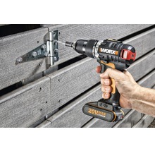 Visseuse sans fil fixant une charnière sur une clôture en bois