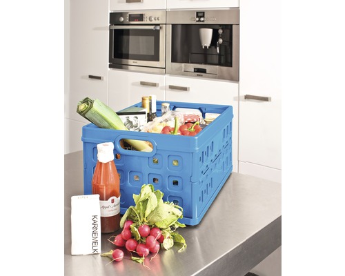 Un panier pliable bleu contenant des aliments sur un plan de travail de cuisine.