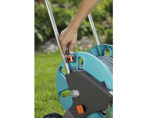 Gartenschlauchwagen mit einer Person, die einen Schlauchanschluss befestigt