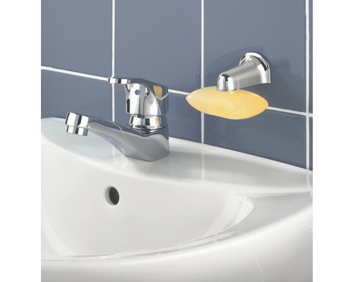 Sur un lavabo se trouvent un robinet et un porte-savon avec du savon.