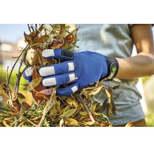 Une main gantée tenant des déchets de jardin.