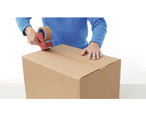 Eine Person verschließt einen Karton mit einem Klebebandabroller.