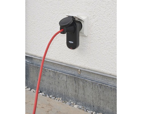 Elektroauto-Ladegerät mit rotem Kabel an einer Wandsteckdose