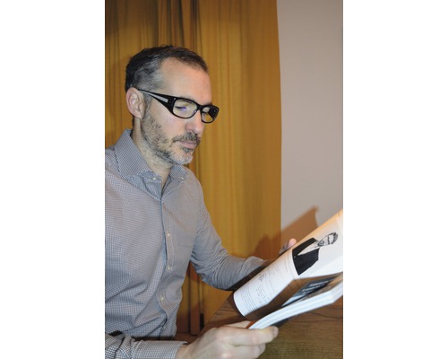 Mann mit Brille liest eine Broschüre