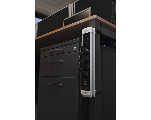 Mehrfachsteckdose mit eingesteckten Stromkabeln im Büro