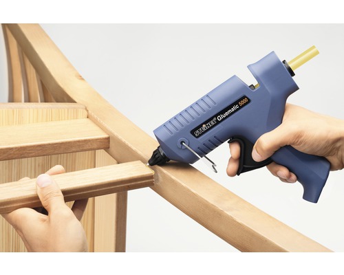 Pistolet à colle chaude en train de coller un cadre en bois