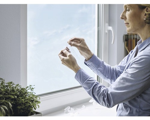 Femme retirant le film protecteur de la vitre