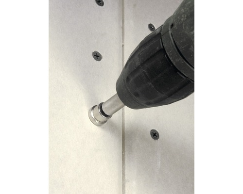 Akkuschrauber befestigt Schraube in einer Wand