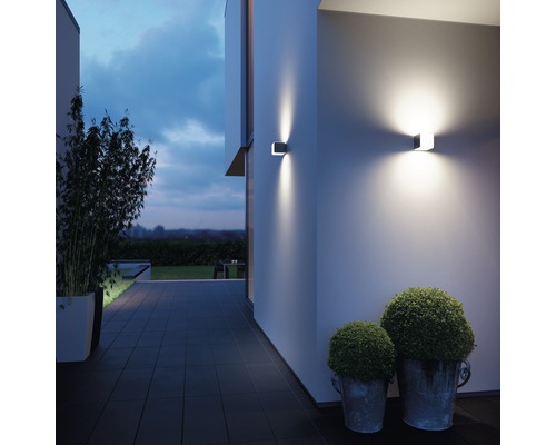 Außenansicht eines Hauses mit zwei modernen Wandleuchten, die die Fassade beleuchten