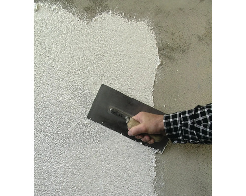 Auftragen von Putz mit einer Glättkelle auf eine Wand.