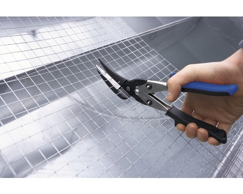 Eine Person schneidet Drahtgitter mit einer Blechschere.