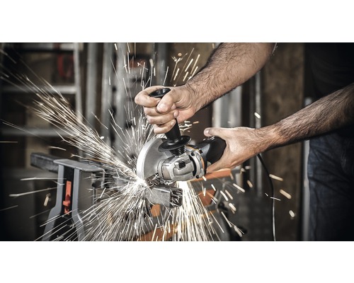Une personne coupe du métal avec une meuleuse d''angle, produisant des étincelles.