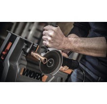 Mann schneidet Kupferrohr mit einem Winkelschleifer in einer Werkbank von Worx