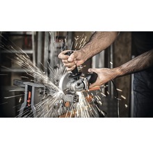 Ein Mann benutzt einen Winkelschleifer zum Schneiden von Metall, wobei Funken fliegen.