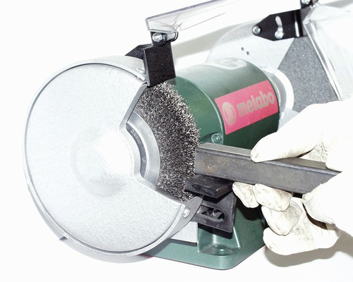 Meuleuse d''établi Metabo avec brosse métallique travaillant sur une pièce de métal