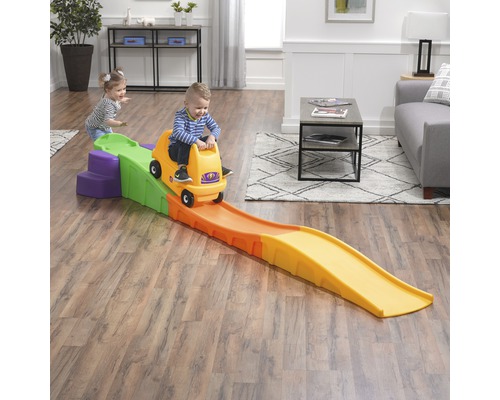 Enfant sur un wagon de montagnes russes jaune Step2 sur des montagnes russes colorées dans le salon.