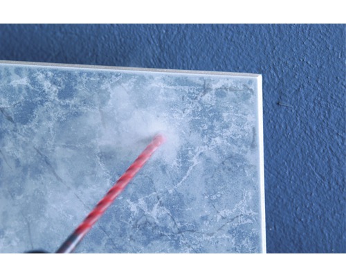 Bohren eines Loches in eine Fliese mit einem Fliesenbohrer