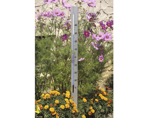 Gartenthermometer zwischen Blumenbeet