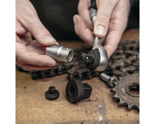 Handwerker hält Ratsche mit Steckschlüsseleinsatz