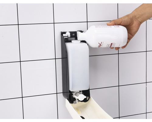 Eine Person füllt einen Seifenspender mit Desinfektionsmittel.