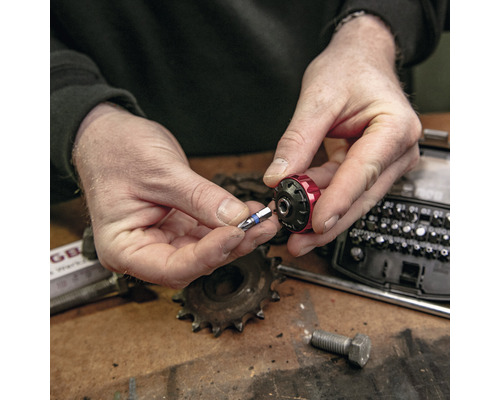 Eine Person setzt einen Schrauberbit in einen Bithalter ein.