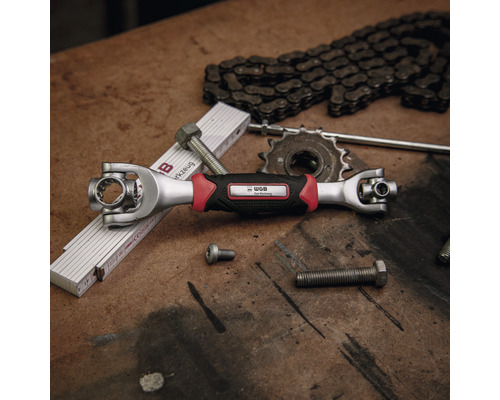 Multifunktionsschlüssel mit Gelenkkopf, Schrauben, Kette und Gliedermaßstab auf einer Werkbank