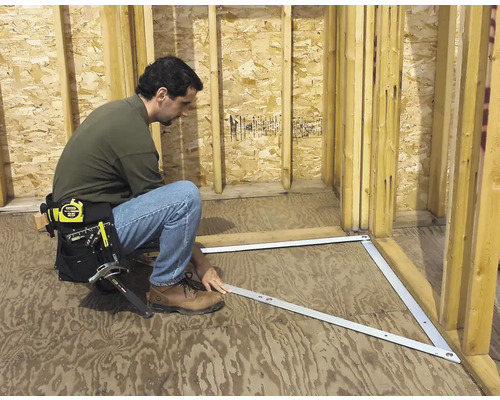 Handwerker montiert rechtwinklige Wand mit Montagewinkel