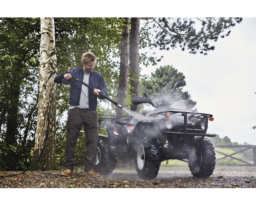 Homme nettoyant un quad avec un nettoyeur haute pression à l''extérieur