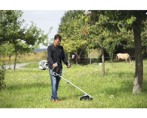 Un homme utilise un coupe-bordure dans un jardin