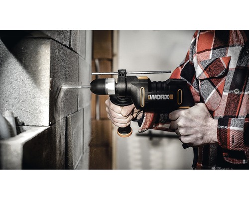 Eine Person bohrt mit einer Worx Schlagbohrmaschine in eine Ziegelwand.