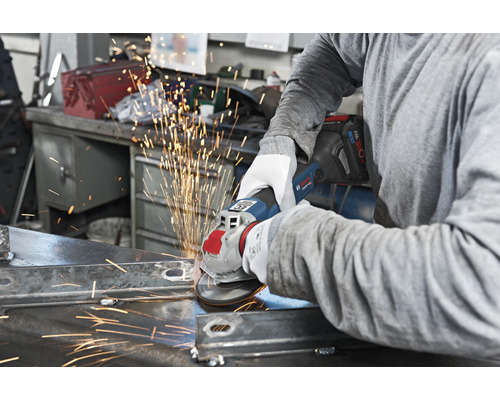 Eine Person schleift Metall mit einem Akku-Winkelschleifer, wodurch Funken entstehen.