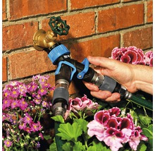 Adaptateur de tuyau d''arrosage fixé à un robinet pour l''arrosage du jardin.