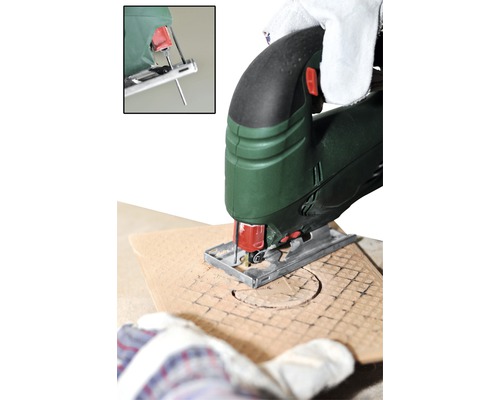 Scie sauteuse en cours d''utilisation pour découper un cercle dans une planche de bois.