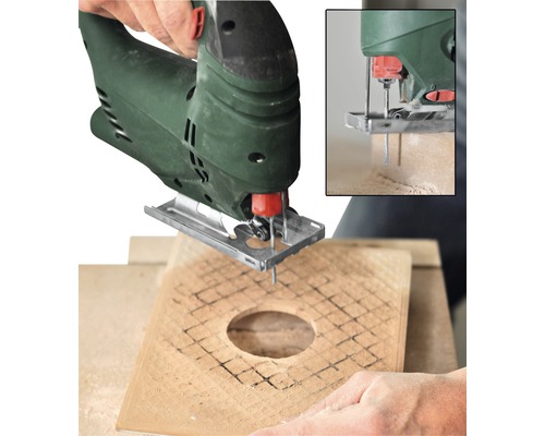 Une scie sauteuse découpe un trou dans une planche de bois.