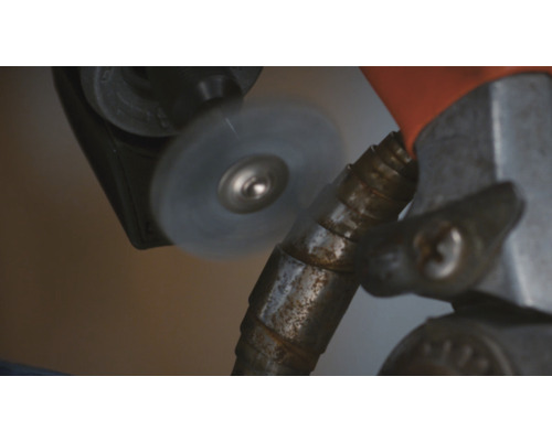 Gros plan d''une brosse rotative utilisée sur un tuyau métallique