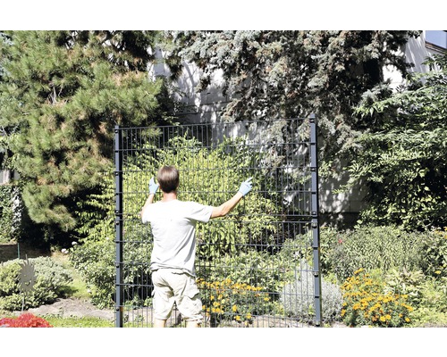 Mann montiert einen Doppelstabmattenzaun im Garten