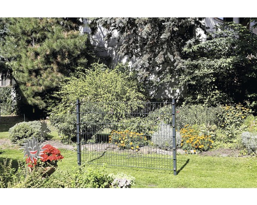 Zaunelement im Garten mit Pflanzen und Bäumen im Hintergrund