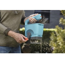 Une personne utilise un épandeur Gardena pour le jardinage