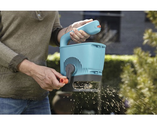 Person benutzt einen Gardena Streuwagen für die Gartenarbeit