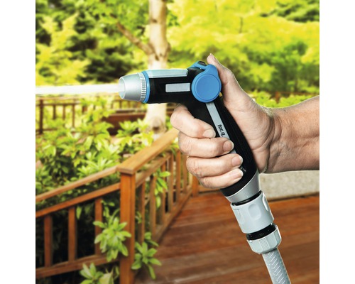 Une main tient un pistolet d''arrosage de jardin à l''extérieur.