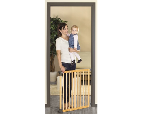 Mère avec enfant devant une barrière de porte en bois